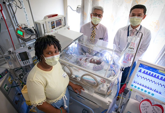 Pediatric heart care team with infant and mom in NICU