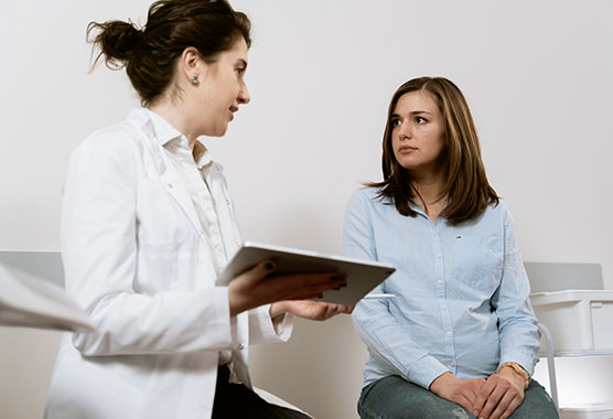Female patient in care room speaking with a female physician