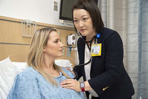 Female doctor listening to a female patient’s heart with a stethoscope