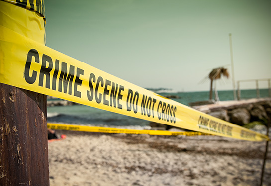 Crime scene tape stretched across a California beach. 