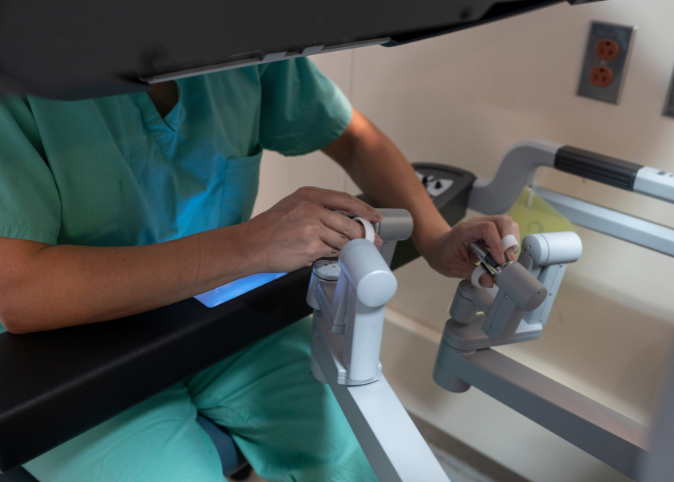 Hands on the controls of a robotic surgery device.
