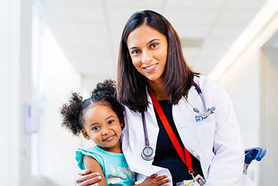 Doctor hugs young female patient.