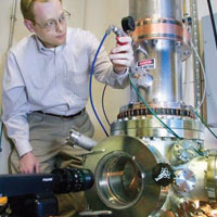 PHOTO — Lawrence Livermore engineer John Harris prepares a vacuum test chamber used in development of the compact proton-beam accelerator.