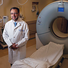 Ramit Lamaba standing next to CT scanner