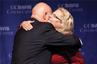 UC Davis Health System Vice Chancellor Claire Pomeroy congratulates Ralph de Vere White, cancer center director