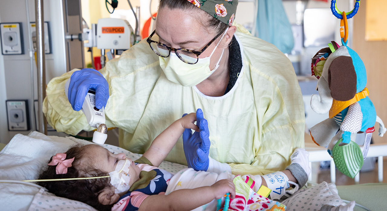Pediatric Intensive Care Unit nurse taking care of a baby