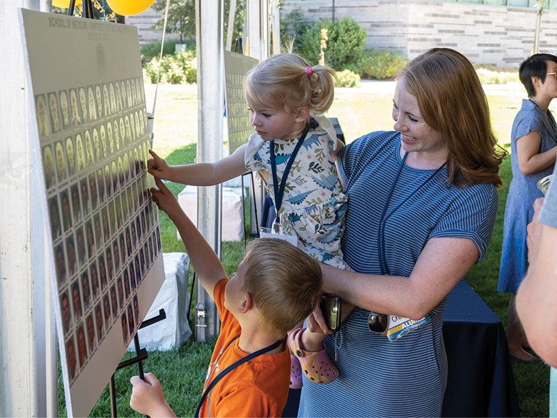 Katie Crean-Tate (M.D. ’13) and kids look at class composite.