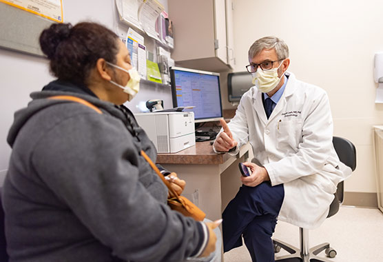 Male health care provider talking to patient in a clinic 