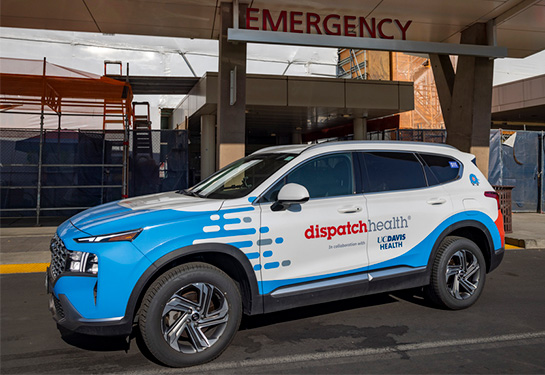 Blue and White car with &#x201c;DispatchHealth&#x201d; and &#x201c;UC Davis Health&#x201d; written on the door