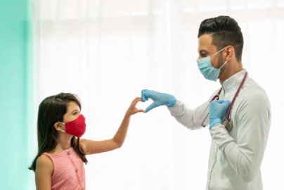 Latino doctor and young patient making a heart with their two hands