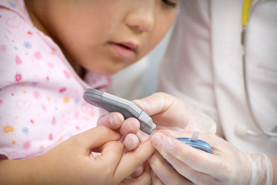 Nurse tests pediatric girl patient using her middle finger prick.