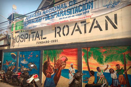 Hospital Roatan, Honduras, building with colorful murals on walls.
